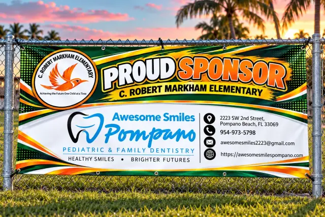 A colorful school sponsor banner on a fence in tropical South Florida light
